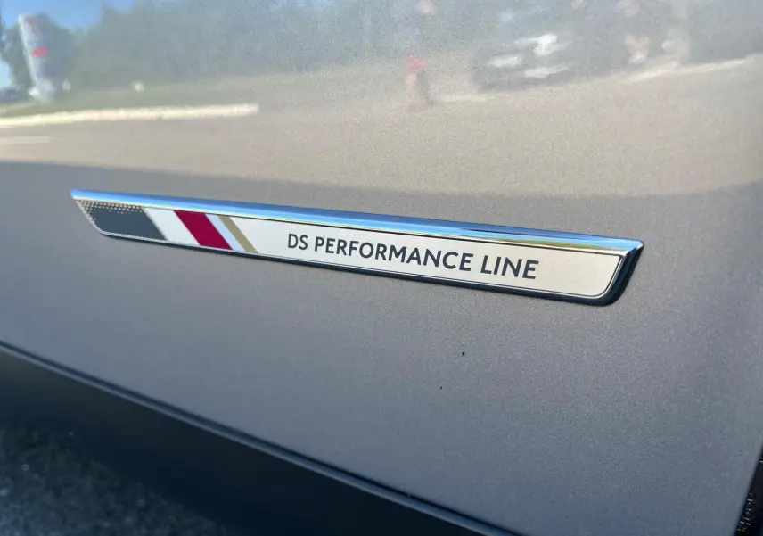 Gros plan sur le badge DS Performance Line sur la portière grise métallisée d'un DS3 Crossback 2022.