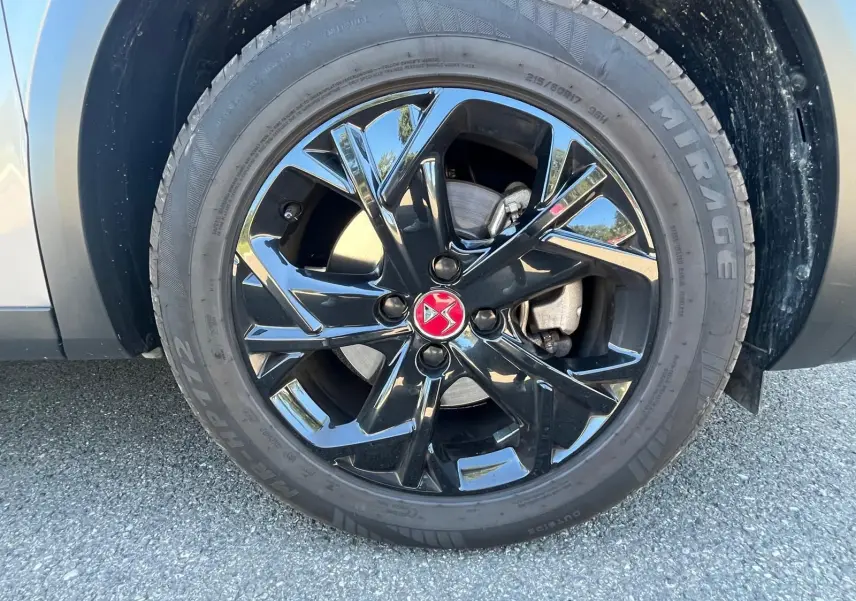 Gros plan sur la jante alliage noire 17" Dubai avec logo DS rouge sur DS3 Crossback Performance Line gris.