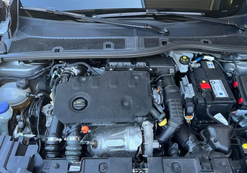 Vue plongeante sur le moteur diesel du DS3 Crossback Performance Line 2022, avec batterie et composants visibles.