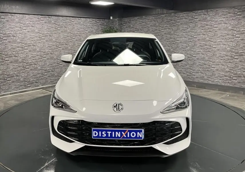 Vue frontale d'une MG3 blanche 2024 avec calandre noire et logo MG au centre dans un showroom.
