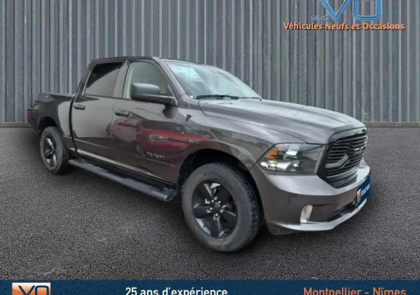 Vue 3/4 avant droit du Dodge RAM Crew SLT Classic Black gris foncé avec jantes noires et calandre sombre, 2022.