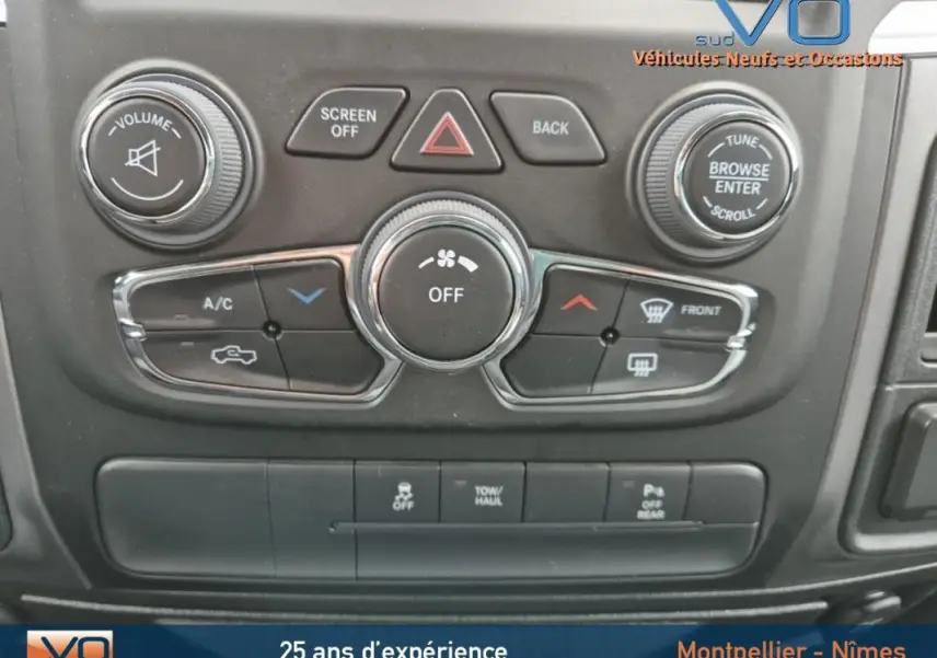 Vue rapprochée du tableau de bord noir du Dodge RAM Crew SLT Classic 2022, montrant les commandes climatisation et audio.