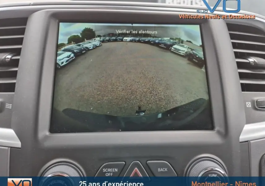 Vue de l'écran de recul du Dodge RAM Crew SLT Classic Black Package gris foncé montrant l'arrière et le pare-chocs du véhicule.