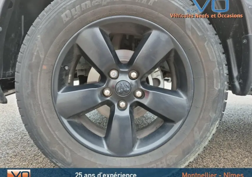 Gros plan sur la jante noire à cinq branches du Dodge RAM Crew SLT Classic Black Package gris foncé de 2022.