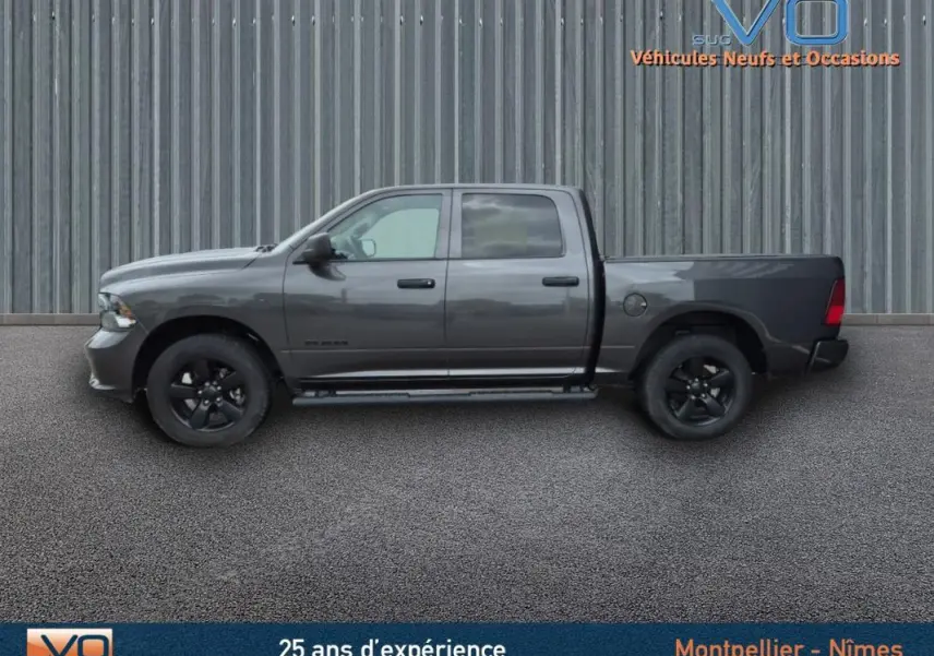 Vue latérale gauche d'un Dodge RAM Crew SLT Classic Black Package gris foncé avec jantes noires, 2022.
