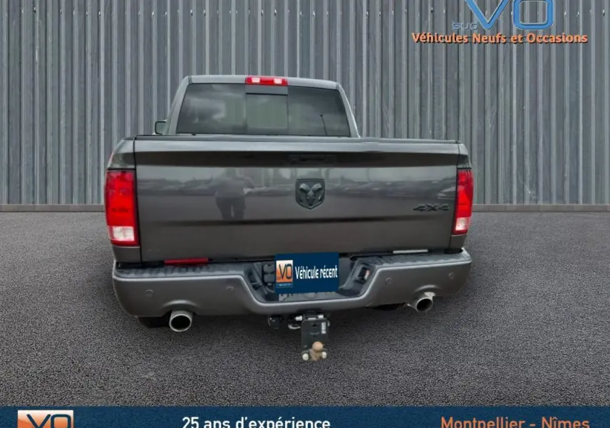 Vue arrière du Dodge RAM Crew SLT Classic Black Package gris foncé 2022 avec attelage et feux rouges visibles.