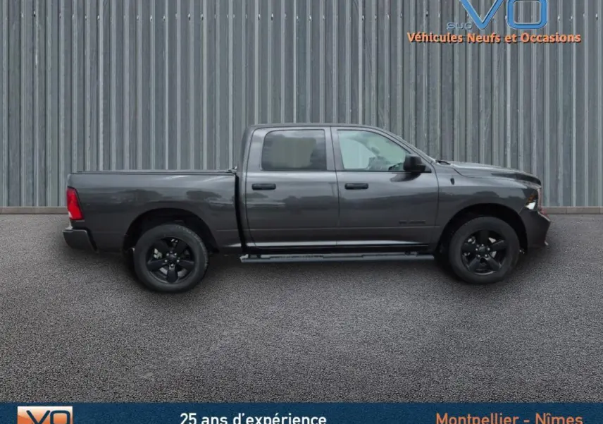 Vue latérale droite d'un Dodge RAM Crew SLT Classic Black Package gris foncé 2022 avec jantes noires et cabine double.