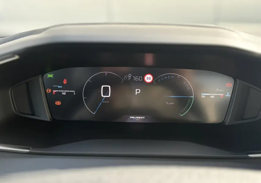 Vue rapprochée du combiné numérique Peugeot 2008 Hybrid 145 e-DSC6 Allure affichant vitesse, mode parking et indicateurs divers.