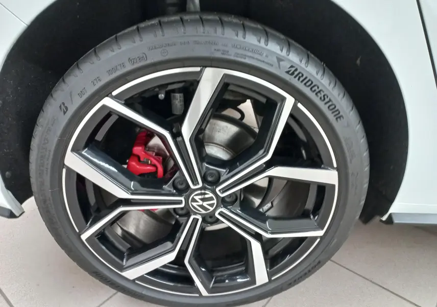 Gros plan sur la roue avant droite d’une Volkswagen Polo GTI 2024, jante noire et argent avec étrier de frein rouge visible.