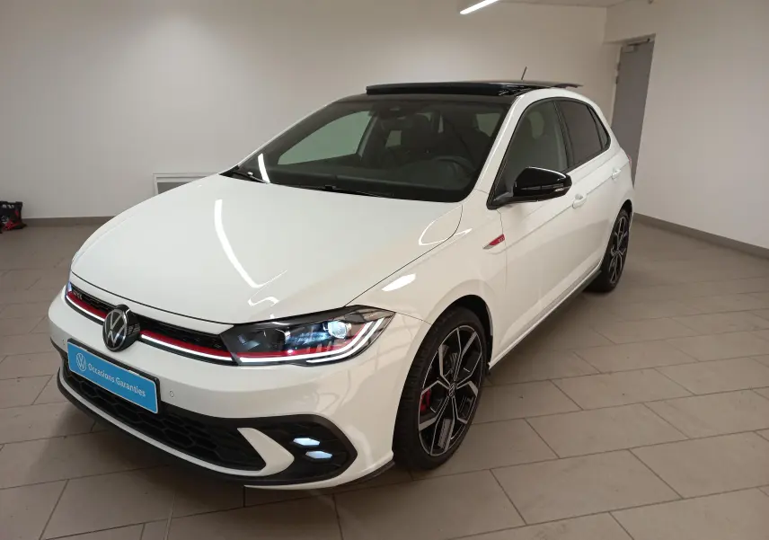 Volkswagen Polo GTI 2024 blanc pur avec toit noir, vue 3/4 avant droit, jantes noires et calandre rouge distinctive.