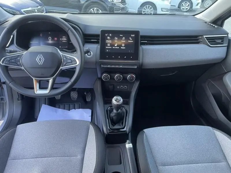 Vue intérieure de face du tableau de bord gris et de la console centrale avec boîte manuelle de la Renault Clio V DCI 100 Evolution 2025.