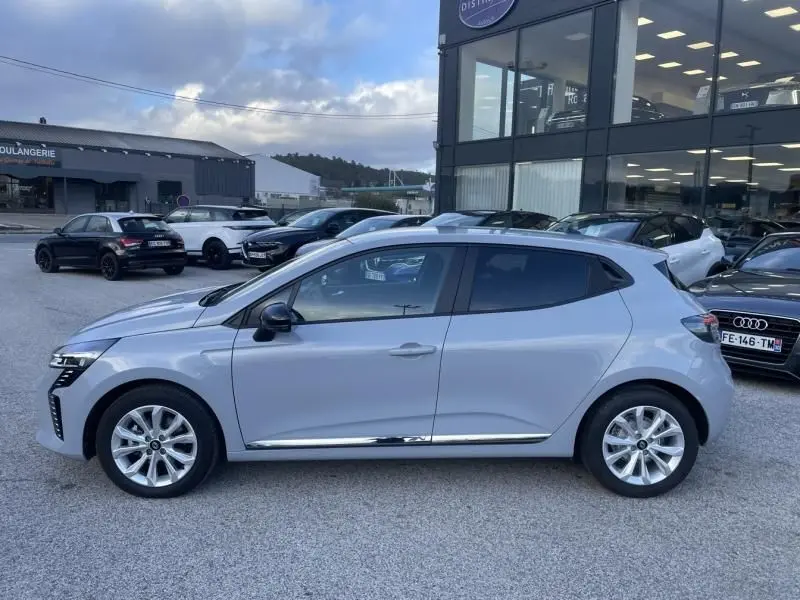 Profil côté gauche d'une Renault Clio V DCI 100 Evolution gris métal 2025, avec jantes alliage et lignes épurées.