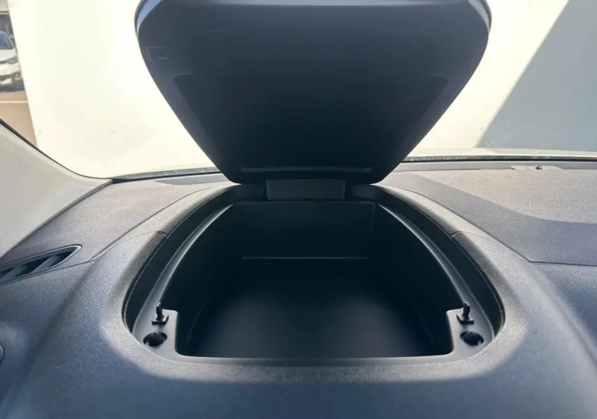 Vue rapprochée du rangement ouvert sur le tableau de bord noir du Citroën Berlingo blanc Icy.