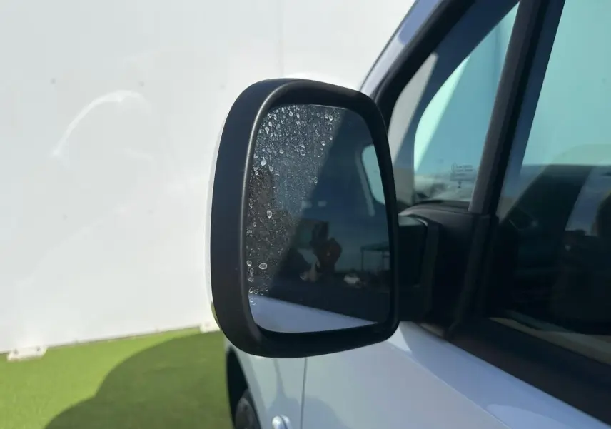 Rétroviseur droit noir brillant du Citroën Berlingo blanc Icy, vue rapprochée sur la portière avant.