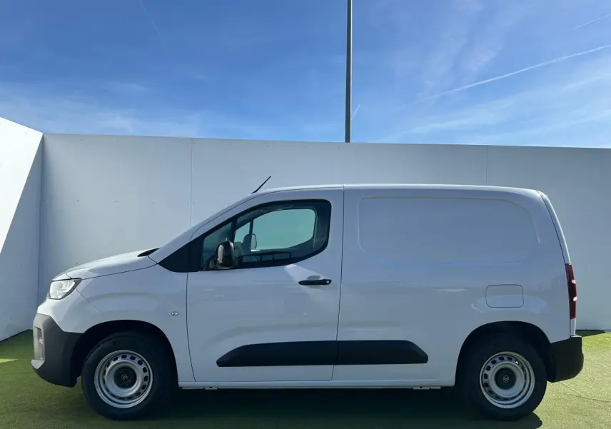 Profil côté gauche d’un utilitaire Citroën Berlingo blanc Icy avec jantes tôles grises et poignées noires.