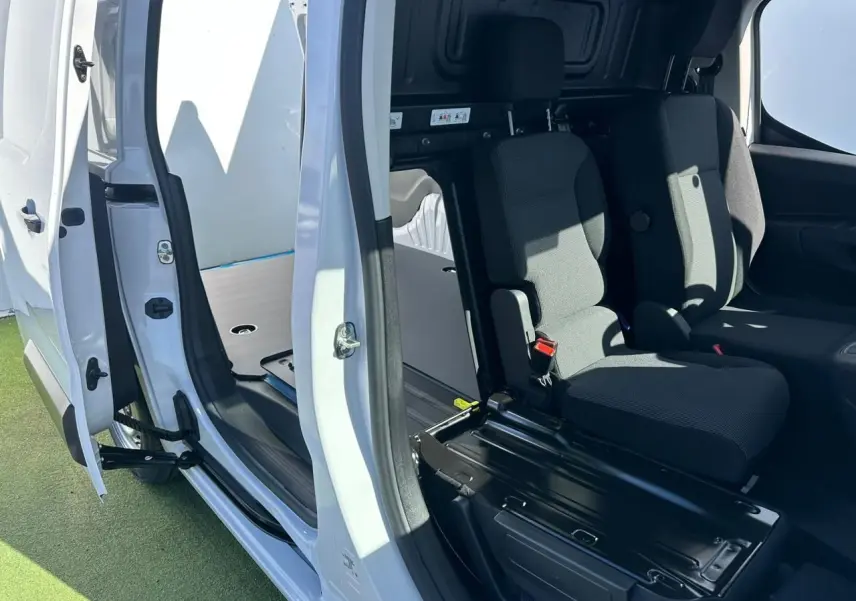 Vue intérieure côté droit du Citroën Berlingo blanc Icy avec porte latérale ouverte et banquette passager 2 places visible.