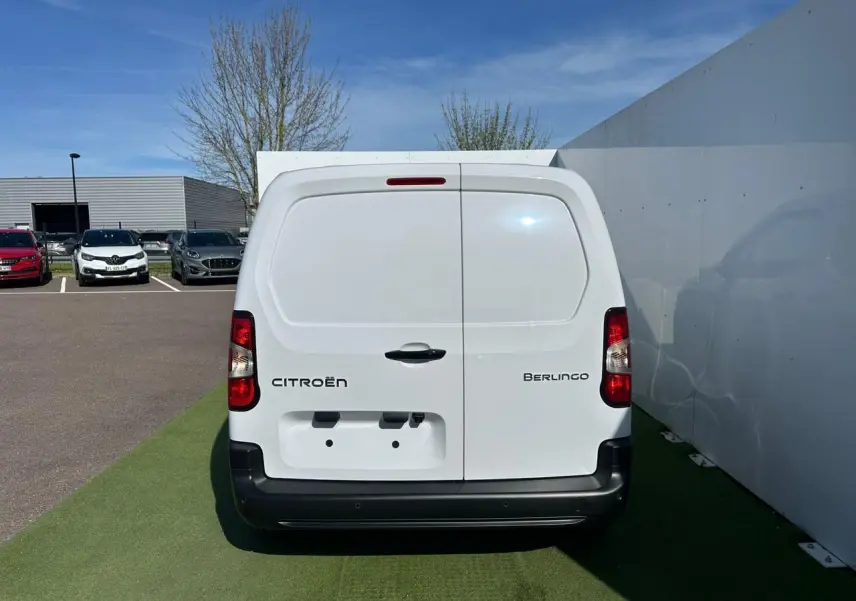 Vue 3/4 arrière droite du Citroën Berlingo blanc Icy version utilitaire avec portes arrière tôlées fermées.