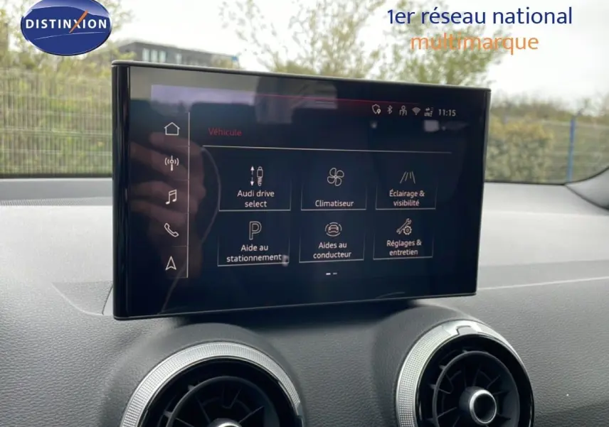 Écran tactile central de l'Audi Q2 2025 noir mito metal, vue intérieure sur la console avec commandes digitales.