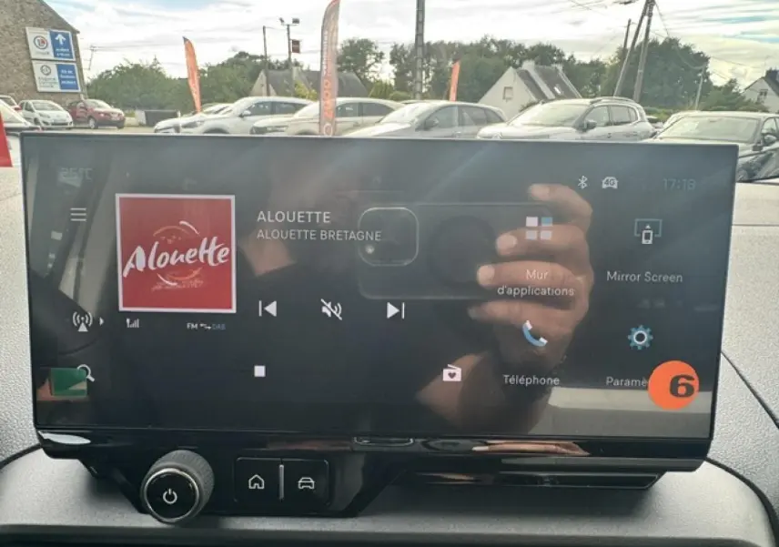 Écran tactile central du Citroën Berlingo gris acier, affichant la radio et commandes multimédia.