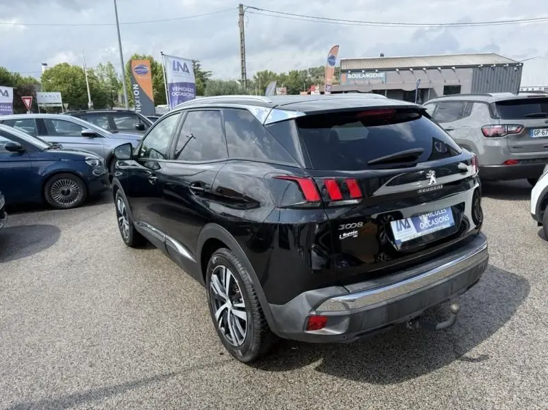 Vue 3/4 arrière droite d'un Peugeot 3008 noir de 2018, avec feux arrière à griffes et jantes alliage distinctives.