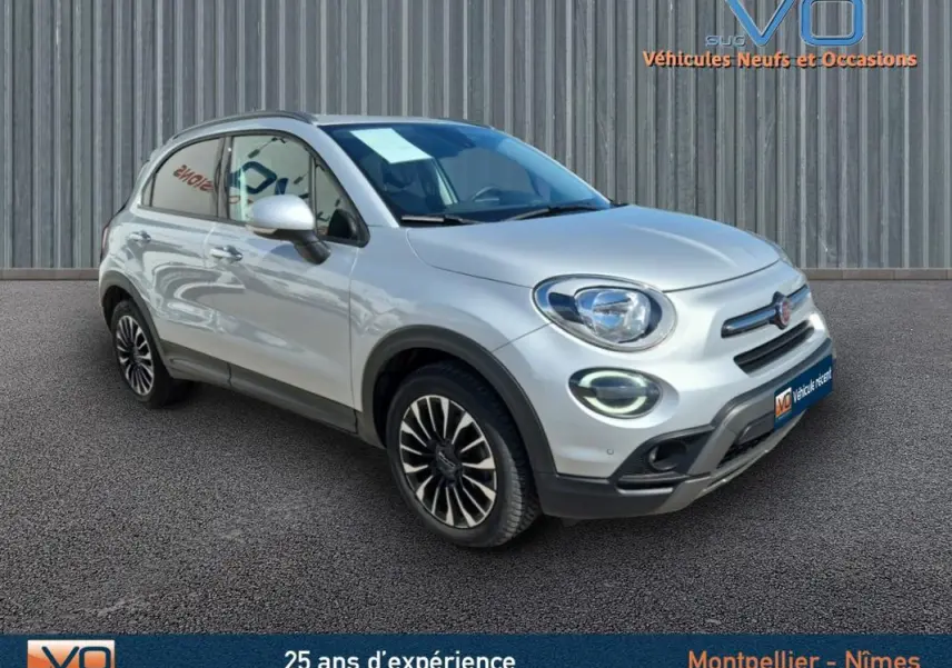 Fiat 500X gris clair vue 3/4 avant droit, jantes alliage 17 pouces et phares à LED visibles.