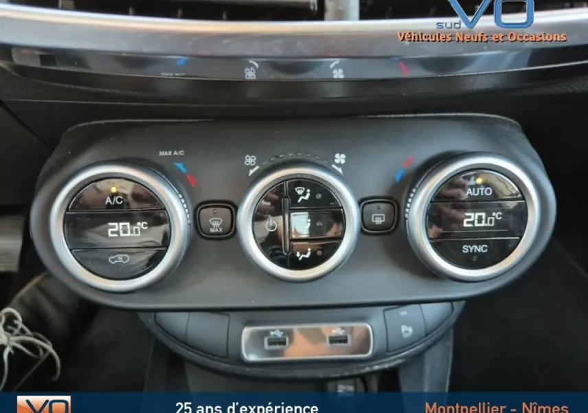 Gros plan sur la commande de climatisation automatique du Fiat 500X gris clair, affichant 20°C et réglages synchronisés.
