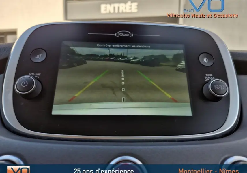 Écran central de la Fiat 500X gris clair montrant la caméra de recul avec guidage de trajectoire coloré.