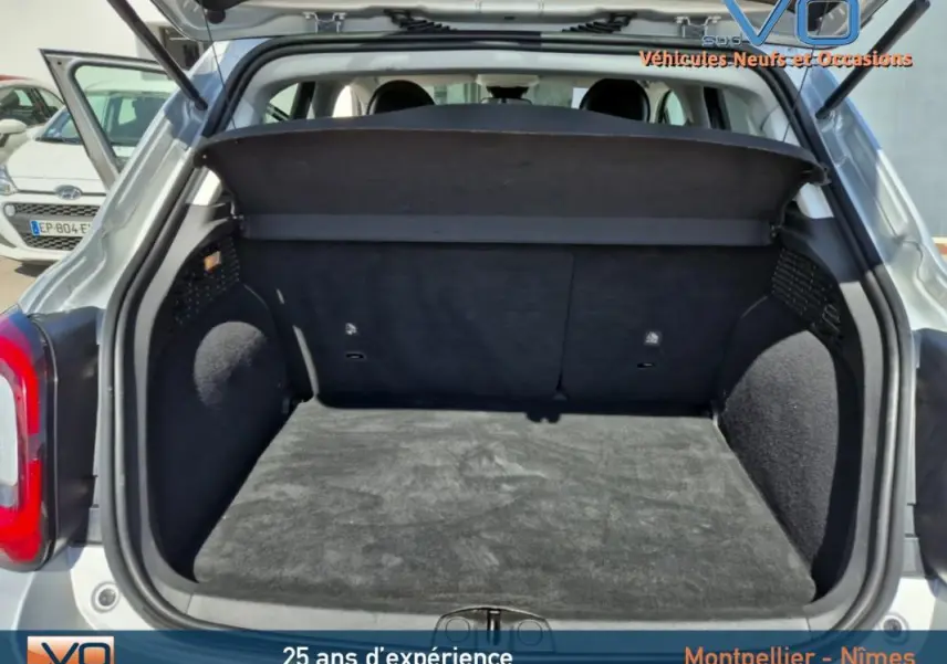 Coffre ouvert vu de l'arrière d'un FIAT 500X gris clair MY21, montrant l'espace de chargement vide et la plage arrière.