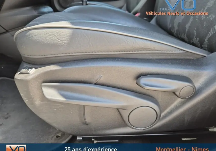 Gros plan sur la manette de réglage en hauteur du siège conducteur noir du Fiat 500X gris clair modèle 2022.