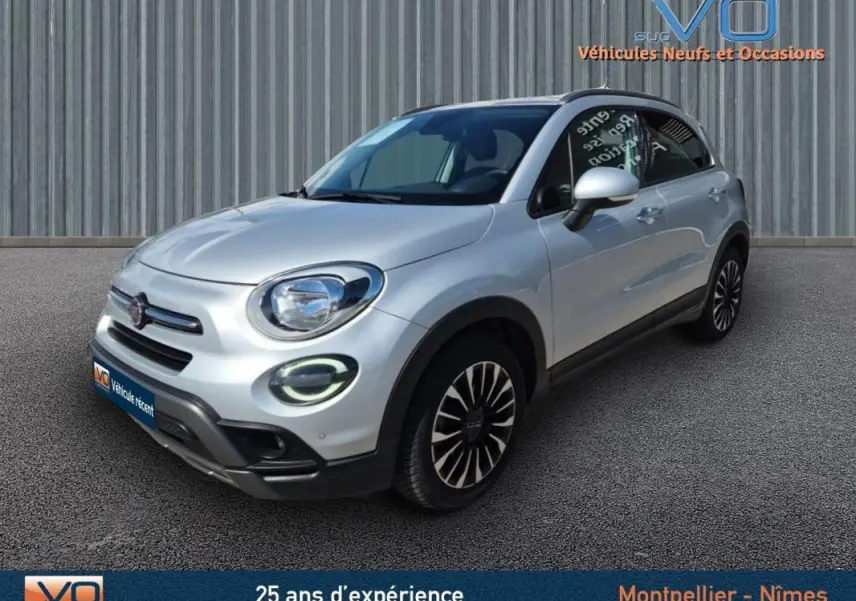 Vue 3/4 avant d'une FIAT 500X MY21 gris clair avec jantes alliage 17 pouces et phares à LED allumés.
