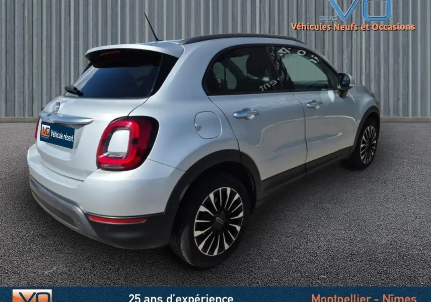 Vue 3/4 arrière droite d'un FIAT 500X gris clair avec jantes alliage 17 pouces sur fond neutre.