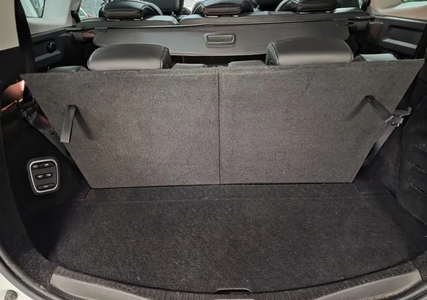 Coffre arrière du Renault Scénic blanc 2017 avec banquette rabattue et commandes électriques côté gauche.