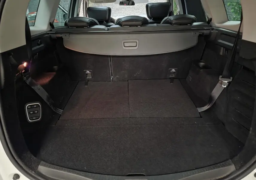 Coffre spacieux ouvert du Renault Scénic blanc 2017 avec banquette arrière et cache-bagages visibles.