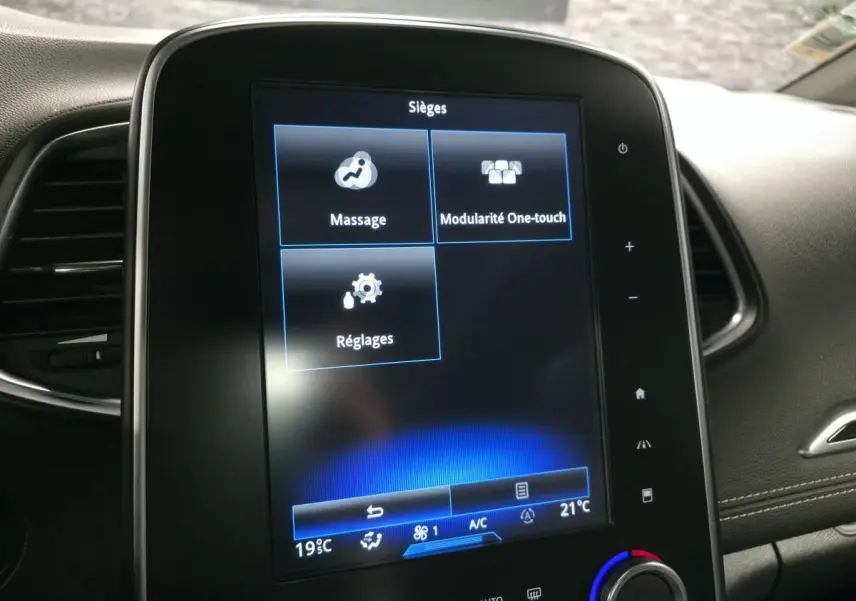 Écran tactile central du tableau de bord du Renault Scenic blanc 2017 affichant les réglages des sièges avec options massage et modularité One-touch.