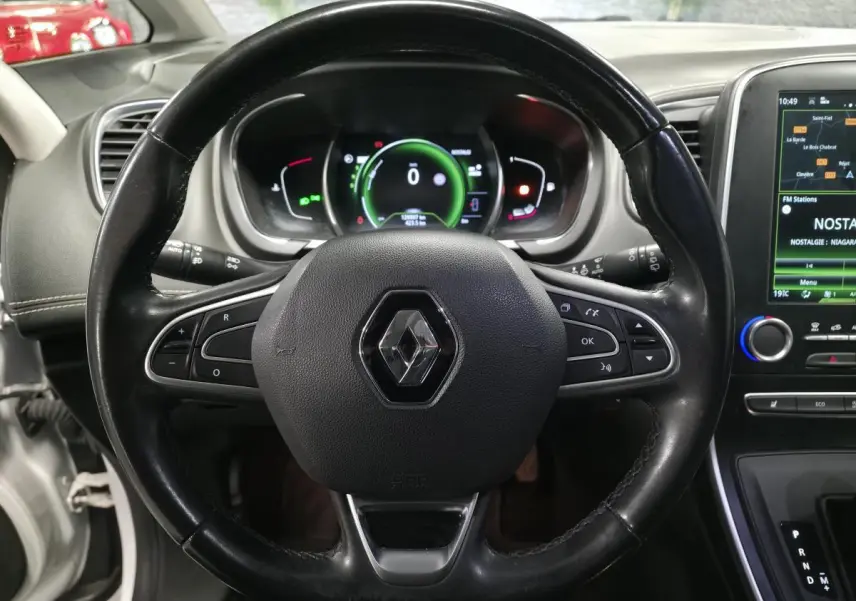 Volant cuir noir avec logo Renault, tableau de bord numérique et écran tactile central dans Renault Scenic blanc 2017.