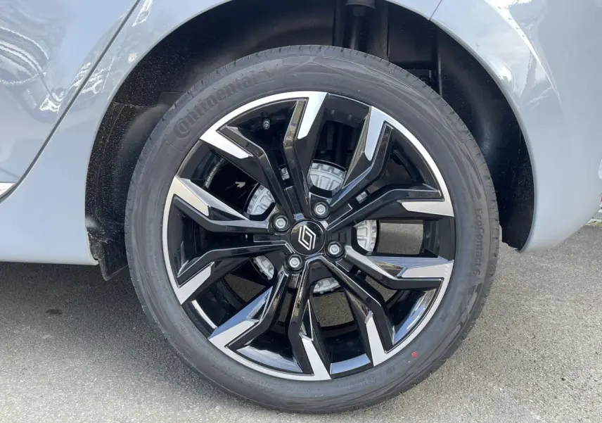 Gros plan sur la jante alliage diamantée 17 pouces noire et argentée de la Renault Clio Gris Rafale côté arrière droit.