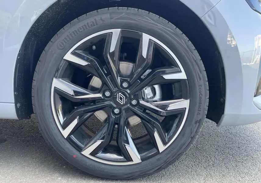 Gros plan sur la jante alliage diamantée 17 pouces noire et argentée du côté avant droit d'une Renault Clio Gris Rafale.