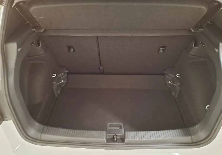 Coffre ouvert du Volkswagen T-Cross blanc pur 2025, vue de l'arrière montrant un espace de rangement propre et spacieux.