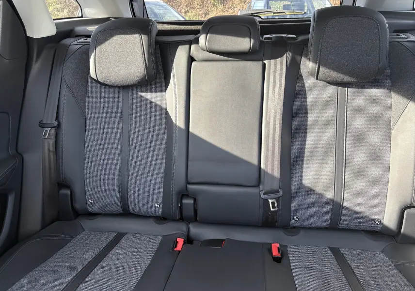 Vue intérieure de la banquette arrière du Peugeot 3008 2019, tissu gris avec inserts en cuir noir et ceintures de sécurité visibles.