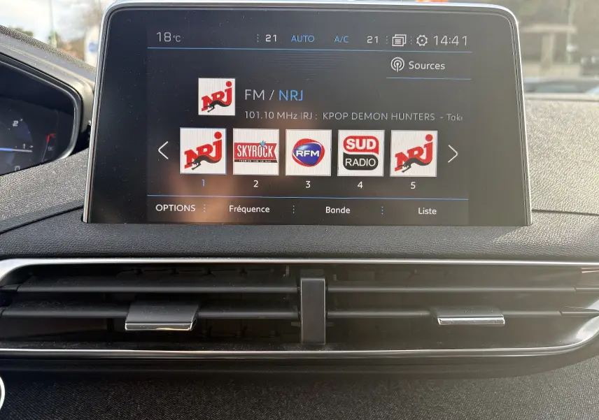 Écran tactile central du Peugeot 3008 II 2019 affichant les stations radio, avec tableau de bord noir et aérateurs en dessous.