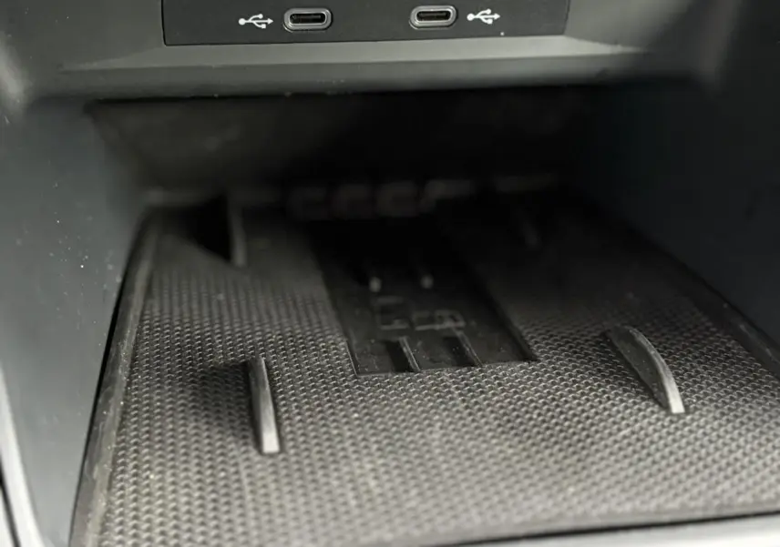 Gros plan sur le chargeur à induction noir avec deux ports USB-C dans la console centrale du CUPRA LEON ST Gris Taiga.