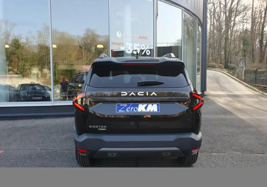 Vue arrière du Dacia Bigster noir Perla avec signature lumineuse LED et toit panoramique visible.