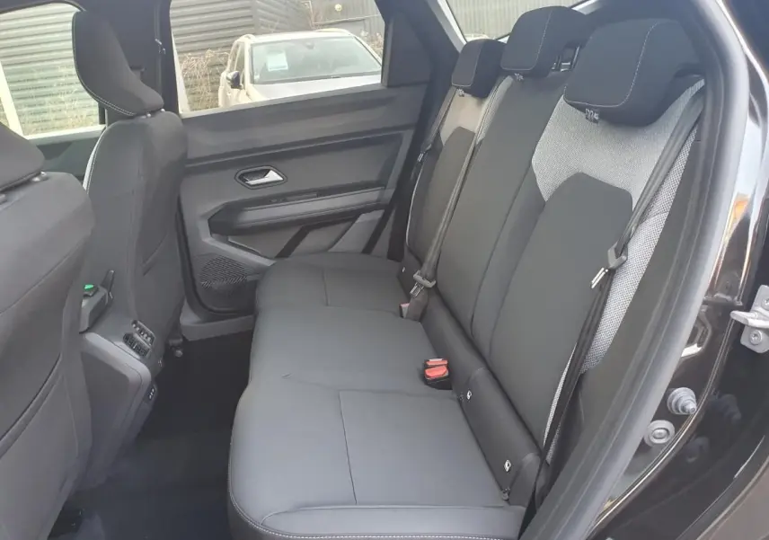 Vue intérieure côté droit sur la banquette arrière noire du Dacia Bigster 2026 avec porte ouverte et ceinture visible.