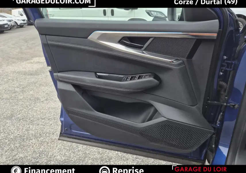 Vue rapprochée de la porte avant gauche bleu foncé du Renault Austral avec garniture noire et inserts métalliques.