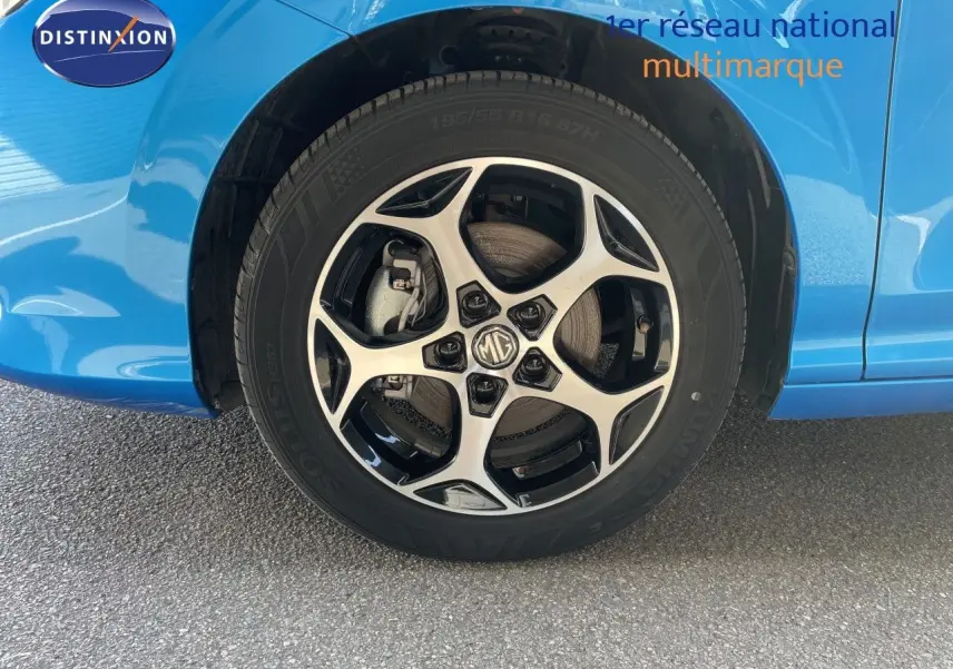 Gros plan sur la roue avant gauche d'une MG3 2025 bleu Como Metal avec jante alliage noire et argentée.