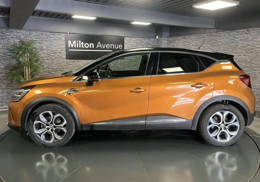Profil droit du Renault Captur 1.6 E-Tech hybride rechargeable 2022 orange avec toit noir et jantes alliage 18 pouces.