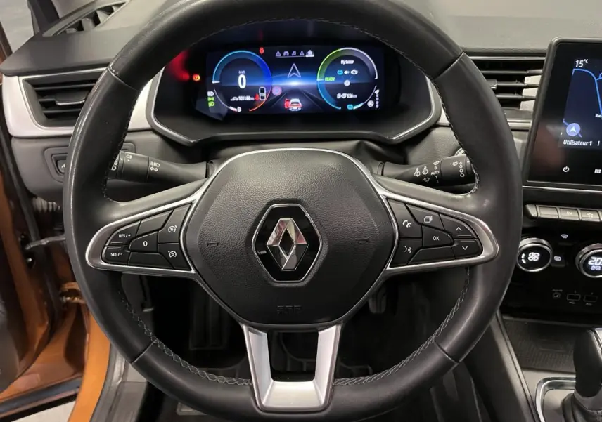 Vue intérieure centrée sur le volant cuir noir du Renault Captur 1.6 E-Tech avec tableau de bord numérique coloré.