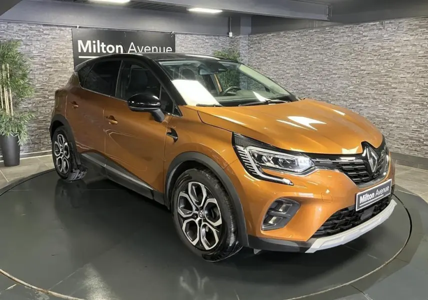 Renault Captur 1.6 E-Tech Hybride rechargeable orange vue 3/4 avant avec toit noir et jantes alliage 18 pouces.