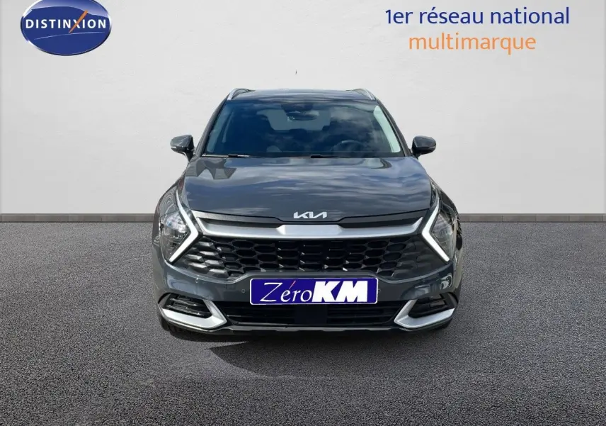 Vue frontale d'un Kia Sportage gris foncé métal 2025 avec calandre large et phares LED en forme de flèche.