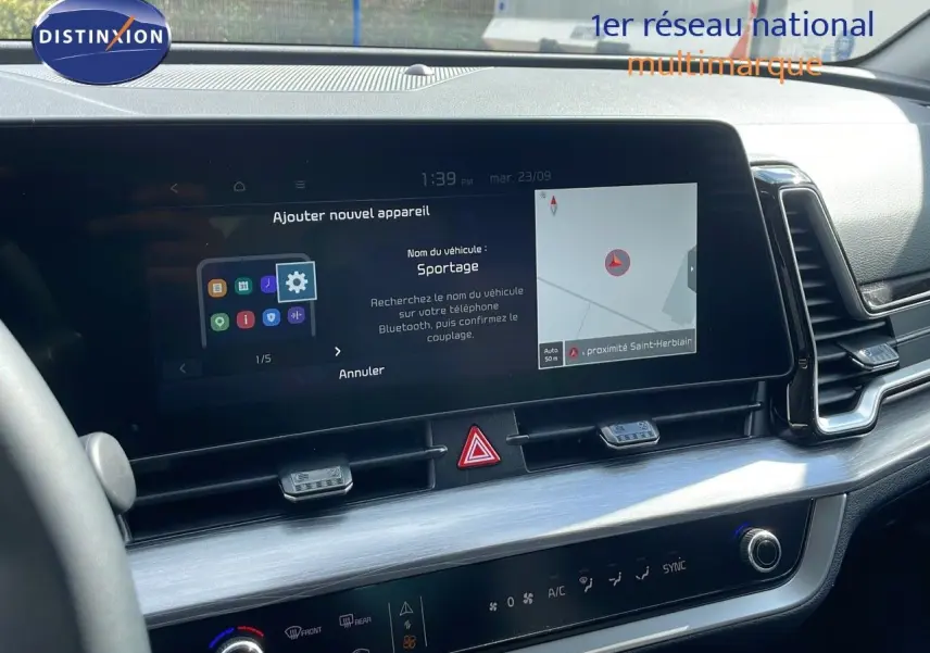 Tableau de bord du Kia Sportage 2025 avec écran tactile central affichant la navigation et les réglages Bluetooth.